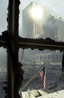 A solitary American flag hangs against the backdrop of debris that was once the World Trade Center in New York Tuesday, Sept. 11, 2001. Planes crashed into the upper floors of both World Trade Center towers minutes apart Tuesday morning, collapsing both 110-story buildings. (AP Photo/Graham Morrison)
